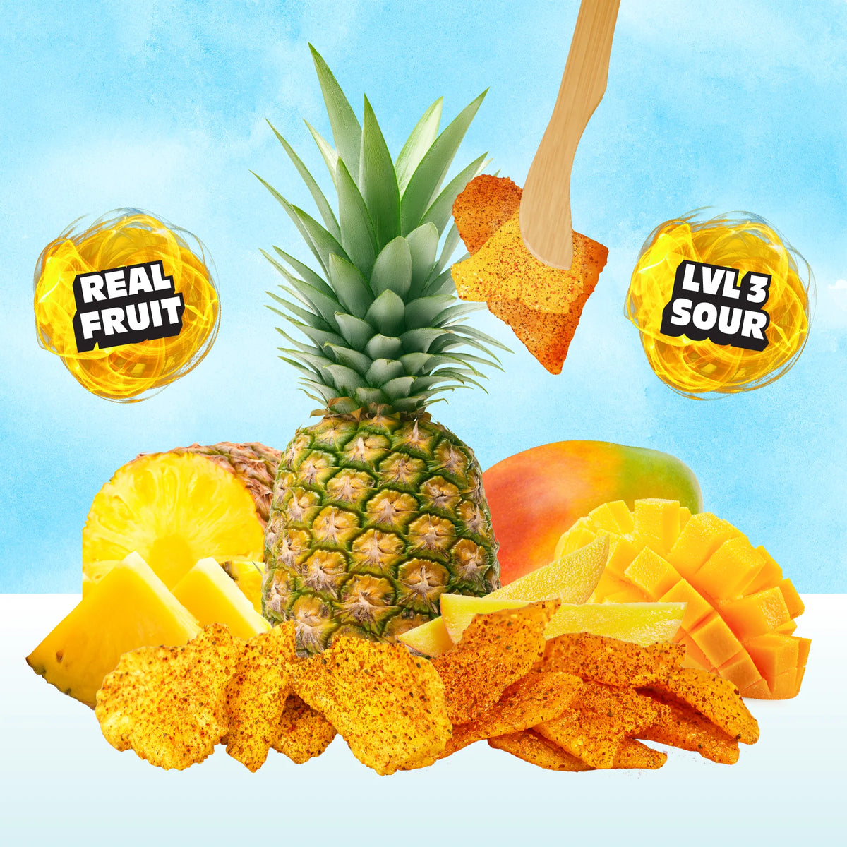 A styled product graphic showing a whole pineapple, sliced pineapple, mango pieces, and scattered orange snack chips on a light blue background, with two circular callouts reading 'REAL FRUIT' and 'LVL 3 SOUR' and a wooden scoop lifting a chip near the top.