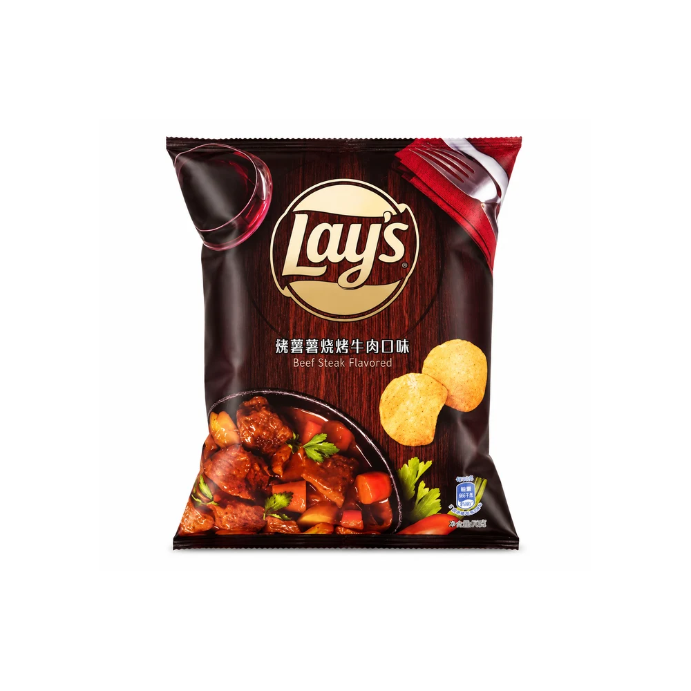 A bag of Lay's Beef Steak Flavored potato chips on a plain white background. The packaging is dark brown with a wood-grain texture, featuring the Lay's logo in gold and white, a red wine glass graphic, a fork, and an appetizing image of beef and vegetables at the bottom.