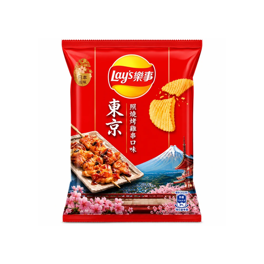 A package of Lay's Tokyo flavor potato chips on a plain white background. The packaging is predominantly red with a yellow Lay's logo, an illustration of grilled skewers, Mount Fuji, and pink cherry blossoms.